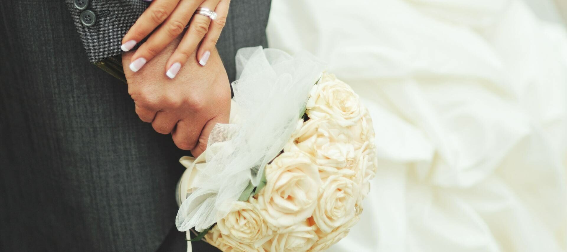 Bride and groom holding hands and wedding bouquet