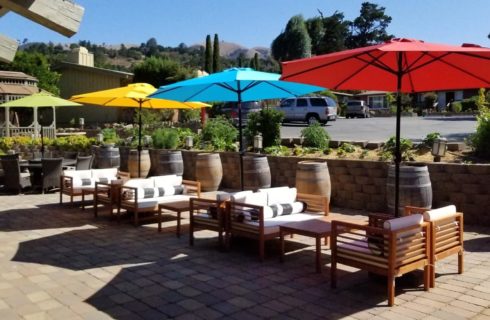Large patio space with multiple seating options and red, yellow, blue, and green umbrellas